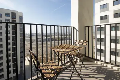 a table and chairs on a balcony with a view at Silk Valley - Luxury 2B steps from Metro station in Dubai