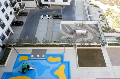 an overhead view of a parking lot with a man on a skateboard at Silk Valley - Luxury 2B steps from Metro station in Dubai