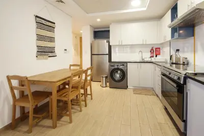 a kitchen with a wooden table and a dining room at Silk Valley - Luxury 2B steps from Metro station in Dubai