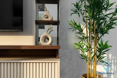 a living room with a plant and two vases on a shelf at Stunning 1BR l JLTl Steps to Metro! in Dubai