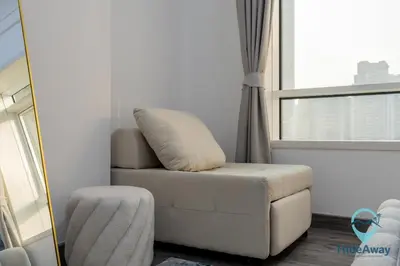 a white chair in a room with a window at Stunning 1BR l JLTl Steps to Metro! in Dubai