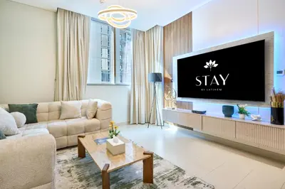a living room with a large tv on a wall at STAY BY LATINEM Luxury 1BR Holiday Home CV B 1506 near Downtown in Dubai