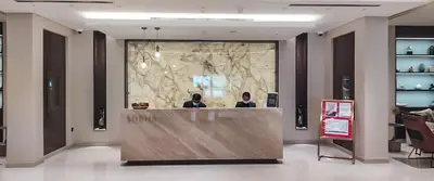 two people sitting at a counter in a lobby at STAY BY LATINEM Luxury 1BR Holiday Home CV B 1506 near Downtown in Dubai