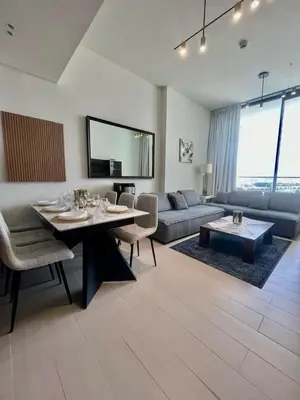 a living room with a table and a couch at Tranquil 1BR in Binghatti Amber with Free Pool & Gym! in Dubai