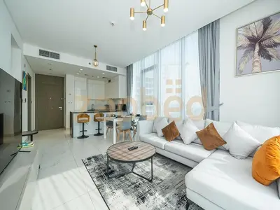 a living room with a white couch and a table at Zapbed House-luxury one bedroom apartment in Residence 16 in Dubai