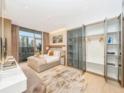 a bedroom with a bed and a large window at Luxurious 3BR Stunning Canal & Burj Khalifa View in Dubai