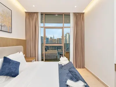 a bedroom with a bed and a large window at Luxurious 3BR Stunning Canal & Burj Khalifa View in Dubai