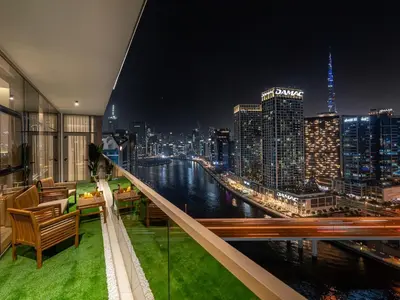 a room with a view of a city at night at Luxurious 3BR Stunning Canal & Burj Khalifa View in Dubai