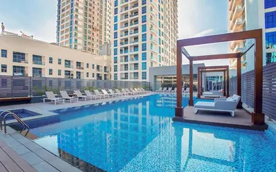 a hotel swimming pool with chairs and a gazebo at GuestReady | Studio | Cozy Apt with Marina View in Dubai