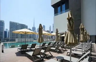a row of lounge chairs and umbrellas on a rooftop at Luxury Studio Business Bay Short Stays Long Stays in Dubai