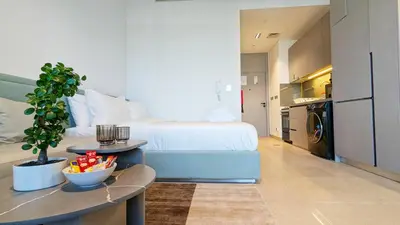 a hotel room with a bed and a kitchen at Stylish MAG City Stay, Near Downtown and MBR City Attractions in Dubai