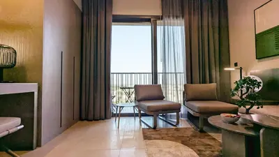 a living room with two chairs and a table at Stylish MAG City Stay, Near Downtown and MBR City Attractions in Dubai