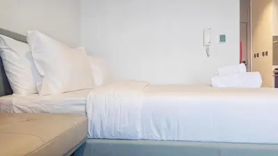 a bedroom with two white beds and a couch at Stylish MAG City Stay, Near Downtown and MBR City Attractions in Dubai