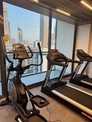 a gym with two cardio machines in front of a window at Luxury Brand new 2BR nearby DIFC in Dubai