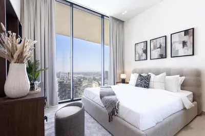 a bedroom with a white bed and large windows at Modern 1B with Private Jacuzzi Binghatti Phantom, JVC in Dubai