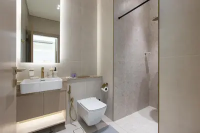 a bathroom with a toilet and a sink and a shower at Modern 1B with Private Jacuzzi Binghatti Phantom, JVC in Dubai