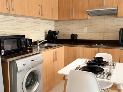 a kitchen with a washing machine and a microwave at ASHRI HH | Spacious Studio in Arjan in Dubai