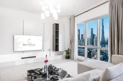 a living room with a tv and a large window at Full Burj Khalifa Fountain View Near Dubai Mall Downtown in Dubai