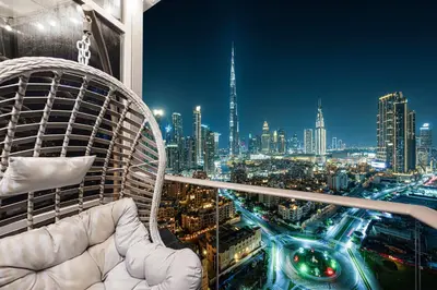 a white chair in a room with a city skyline at Full Burj Khalifa Fountain View Near Dubai Mall Downtown in Dubai