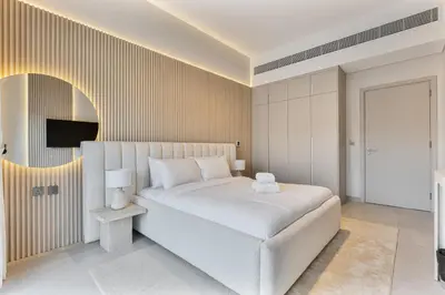a white bedroom with a white bed and a tv at MAG City Private Villa, 3BR with Pool, Garden & BBQ in Dubai