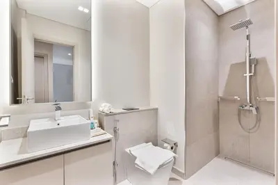 a white bathroom with a sink and a shower at MAG City Private Villa, 3BR with Pool, Garden & BBQ in Dubai