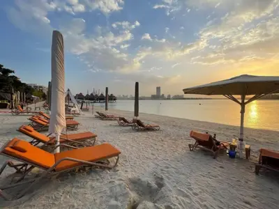 a group of lounge chairs and umbrellas on a beach at FIRST CLASS 1BR Serene Sea View Royal Amwaj in Dubai