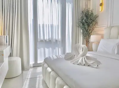 two swans sitting on a bed in a bedroom at Luxury 1Bedroom Burj Khalifa View from Infinity Pool Grande Signature Residences in Dubai