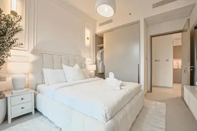 a white bedroom with a large bed and a bathroom at Luxury 1Bedroom Burj Khalifa View from Infinity Pool Grande Signature Residences in Dubai