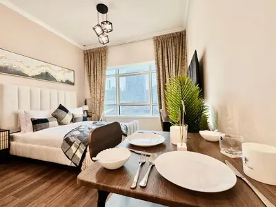 a living room with a bed and a table and a room at Cosmos Living Work-Friendly with Easy Metro Access in Dubai