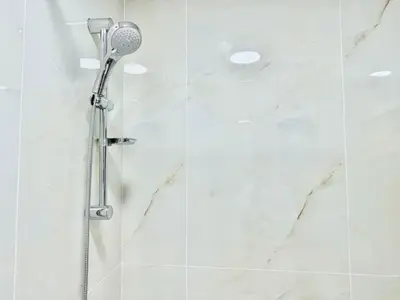 a shower with a shower head in a bathroom at Cosmos Living Work-Friendly with Easy Metro Access in Dubai