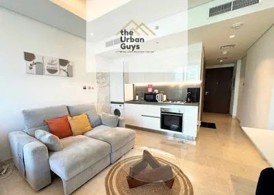 a living room with a couch and a kitchen at Livo in Dubai