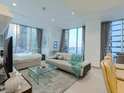 a living room with a couch and a tv at Cayan Tower, The Twist - Marina Views & Free Pool in Dubai
