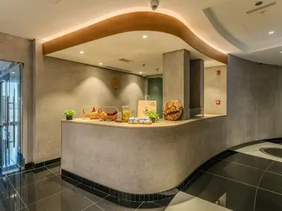 a lobby with a counter with food on it at Cayan Tower, The Twist - Marina Views & Free Pool in Dubai
