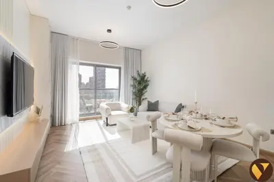 a white living room with a table and chairs at Vogue JVC Jeewar Tower Near Circle Mall, One Bedroom Apartment with Balcony and City View, Access to all Amenities in Dubai