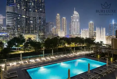 a swimming pool with a city skyline in the background at Address Residences Dubai Opera 3-bed Full Burj & Fountain View, Downtown Dubai in Dubai