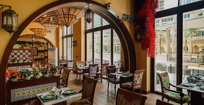 a restaurant with tables and chairs and a large window at Address Residences Dubai Opera 3-bed Full Burj & Fountain View, Downtown Dubai in Dubai