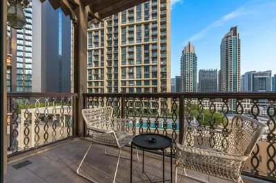 a balcony with chairs and a table and a city skyline at Charming Oasis Near Dubai Mall & Burj Khalifa in Dubai