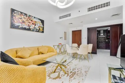 a living room with a yellow couch and a table at Charming Oasis Near Dubai Mall & Burj Khalifa in Dubai