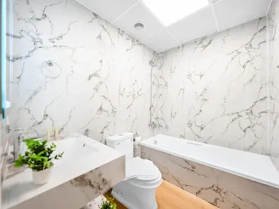 a white bathroom with a toilet and a bath tub at New Lux 3BR Apartment High Floor Prime Location BCOM in Dubai
