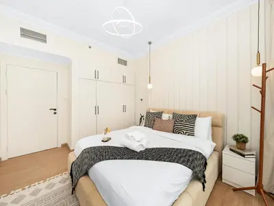 a bedroom with a large bed with white walls at New Lux 3BR Apartment High Floor Prime Location BCOM in Dubai