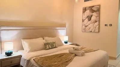 a bedroom with a large bed and a painting on the wall at ASHRI HH | Elegant 2 BHK| Downtown Dubai | 8Blvd in Dubai