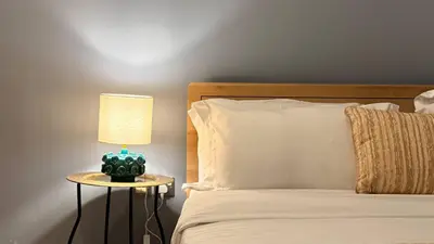 a bed with a lamp on a table next to it at ASHRI HH | Elegant 2 BHK| Downtown Dubai | 8Blvd in Dubai