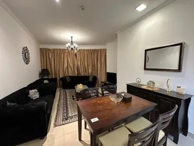 a living room with a table and a dining room at Cosy 1 Bed in JLT in Dubai