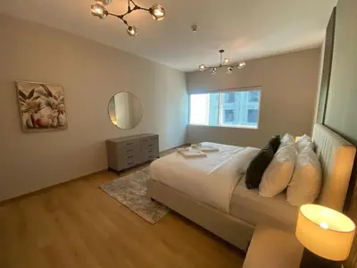 a bedroom with a large bed and a window at Comfy 1 Bedroom in Dubai Marina in Dubai