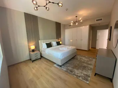 a bedroom with a large white bed and a rug at Comfy 1 Bedroom in Dubai Marina in Dubai