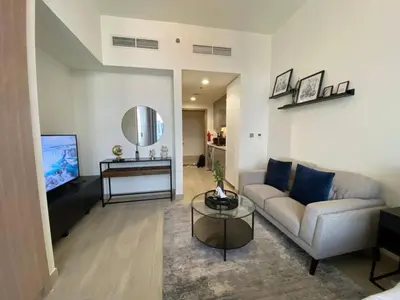 a living room with a couch and a table at Modern Studio with Balcony - Pool View in Dubai