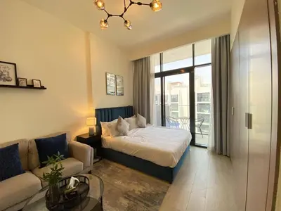 a hotel room with a bed and a couch at Modern Studio with Balcony - Pool View in Dubai