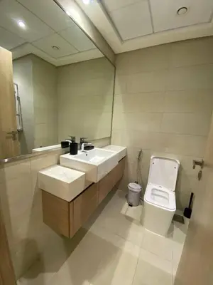a bathroom with a sink and a toilet and a mirror at Modern Studio with Balcony - Pool View in Dubai