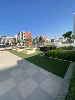 a piano in a park with buildings in the background at Bright Studio - Azizi Riviera 35 - Fully Furnished in Dubai