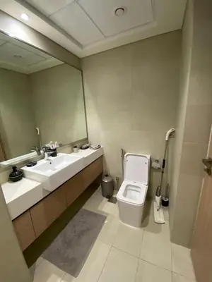 a bathroom with a toilet and a sink and a mirror at Bright Studio - Azizi Riviera 35 - Fully Furnished in Dubai